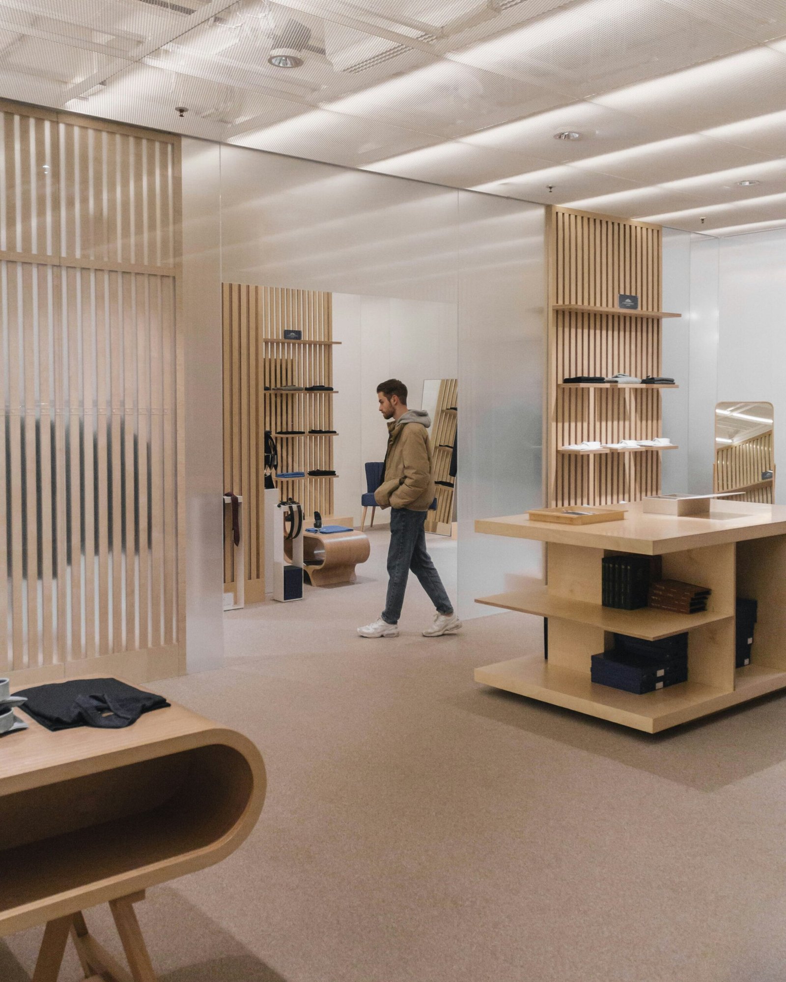 Warm minimalist commercial interior with wood slat paneling and retail shelving
