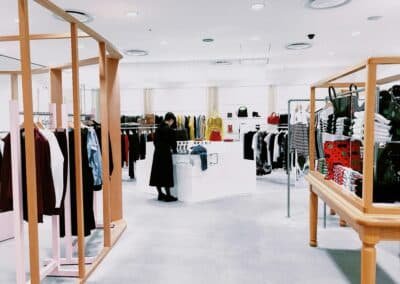 Bright modern retail store interior with wood clothing racks and merchandising displays