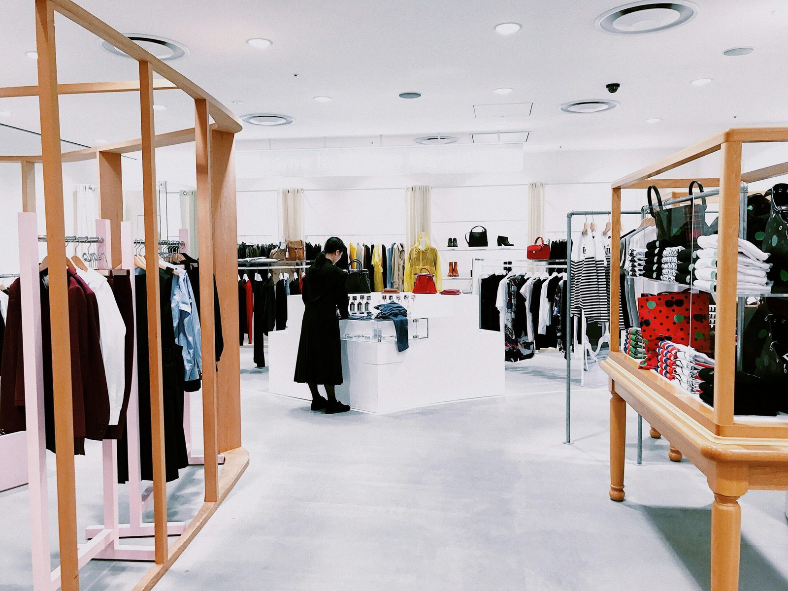 Bright modern retail store interior with wood clothing racks and merchandising displays
