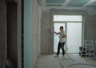 Contractor applying finish to a wall during commercial space construction